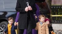 Elon Musk leaving a meeting with three children.