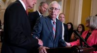 Senate Minority Leader Mitch McConnell being assisted by colleagues.