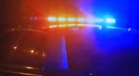 Blurred photo of a police car at night with flashing lights.