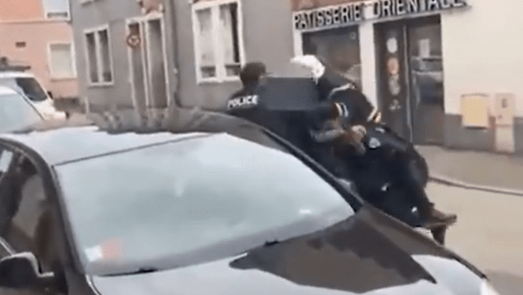 Police officers arresting a suspect on a city street.
