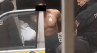 Shirtless man being arrested by police.