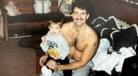 Photo of a shirtless man holding a young boy.
