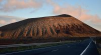 Road leading to volcano at sunset.