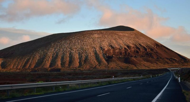 Road leading to volcano at sunset.