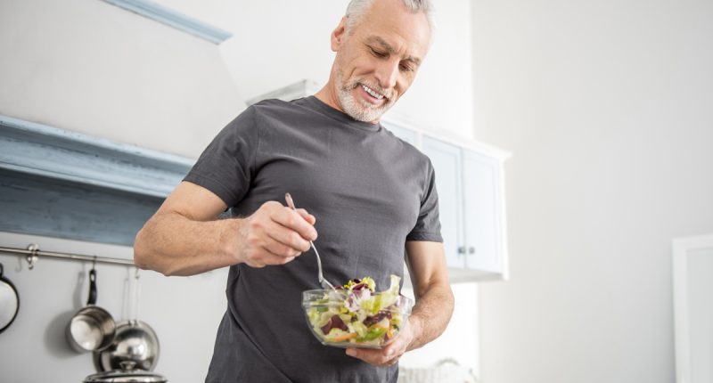 mature older man eating salad
