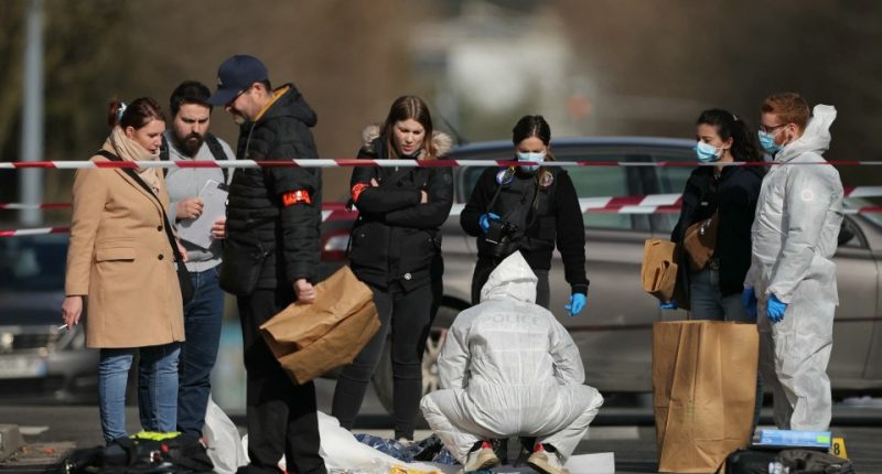 Police officers and forensic investigators at a crime scene.