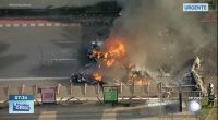 Burning wreckage of a plane crash on a roadway.