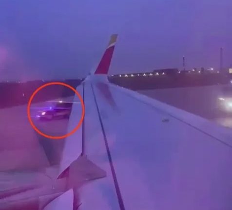 Video still of emergency responders detaining a passenger on the tarmac after he opened an emergency exit on a plane.