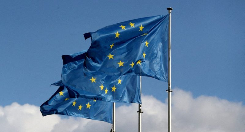 Three European Union flags waving in the wind.