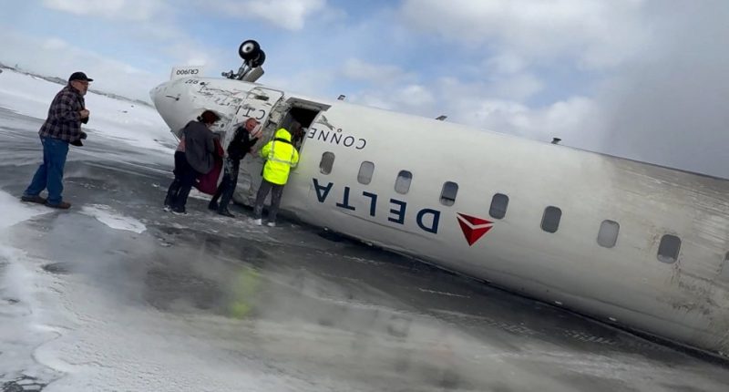 Passengers exiting a crashed Delta Air Lines CRJ-900 jet on an icy runway.