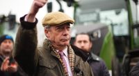 Nigel Farage giving a thumbs-up while speaking into a microphone.