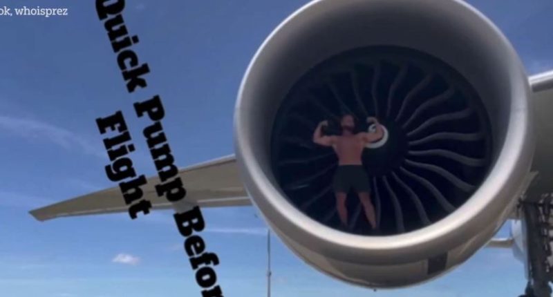 Bodybuilder flexing inside an airplane engine.