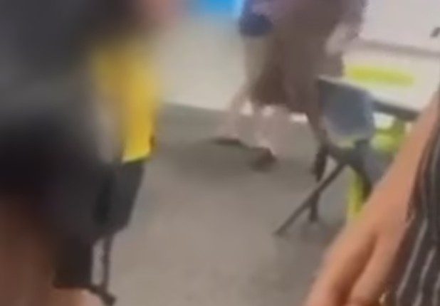 A mother confronting her daughter's bully in a classroom.
