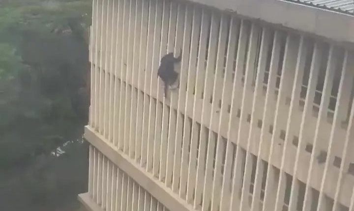 Man escaping from a courthouse window.