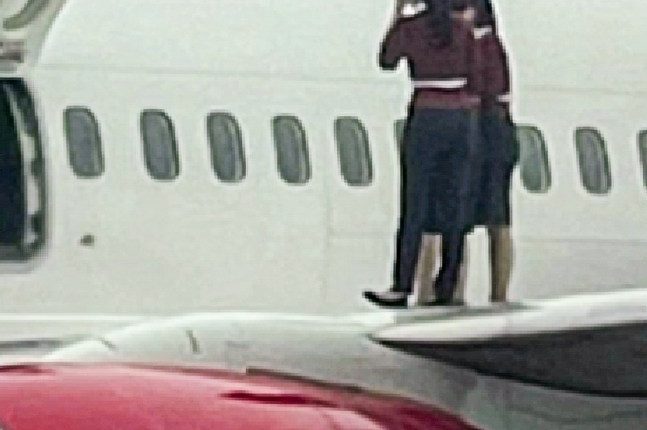 Flight attendants on the wing of an Eastar Jet plane.