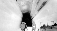 Black and white photo of people near an ice tunnel.