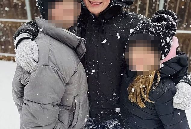 Woman playing in the snow with two children.