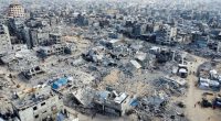 Drone view of destroyed buildings and Palestinians walking amidst rubble in Khan Younis, Gaza Strip.