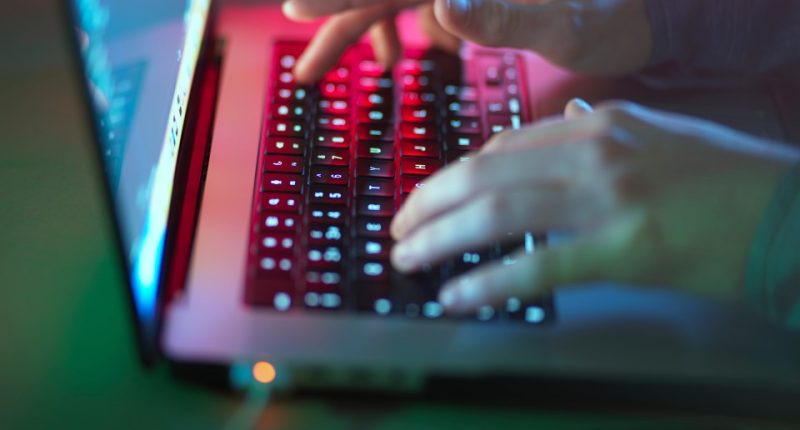 Person typing on a laptop at night.