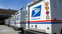 Row of USPS delivery trucks.