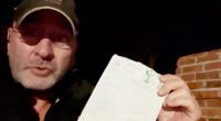 Man holding a USPS delivery slip.