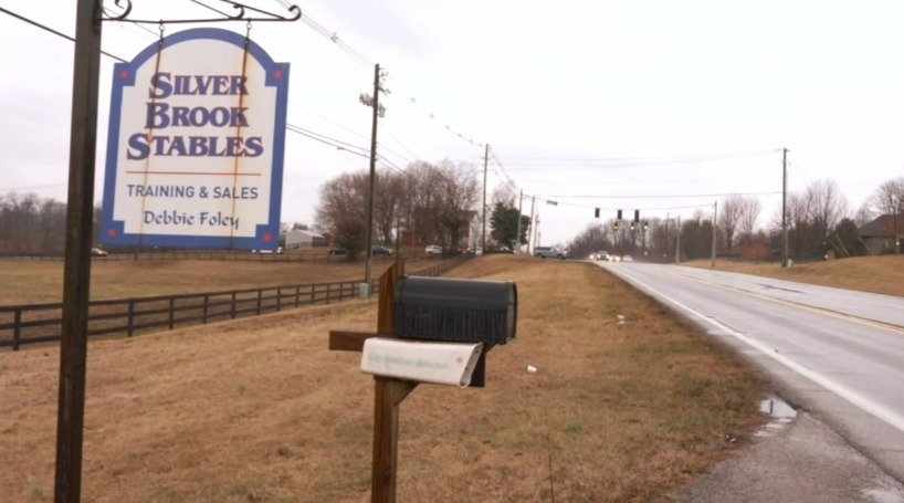 Silver Brook Stables sign and mailbox by a road.