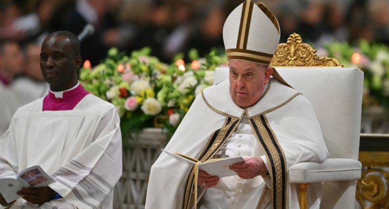 Pope Francis seated, reading a book.