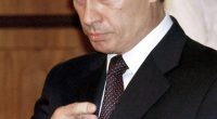 Vladimir Putin gesturing during a meeting.