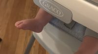 Baby's feet in a Graco high chair.