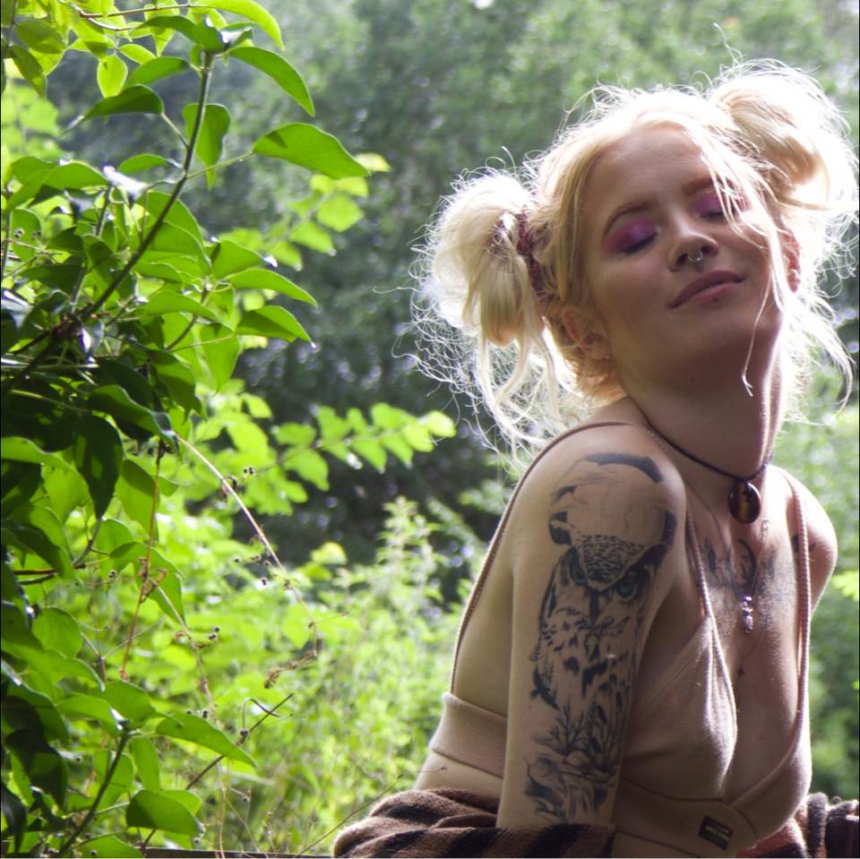 Woman with owl tattoo outdoors.