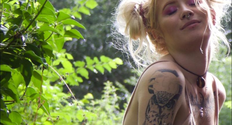 Woman with owl tattoo outdoors.