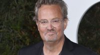 Matthew Perry in front of a step and repeat at an event.