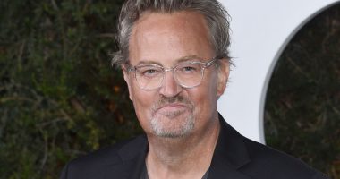 Matthew Perry in front of a step and repeat at an event.