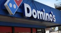 CHICAGO, ILLINOIS - OCTOBER 14: A sign hangs above the entrance of a Domino's restaurant on October 14, 2022 in Chicago, Illinois. Domino's, America's largest pizza chain, reported a rise in third quarter sales of 2% in the U.S. and revenue growth of 7.1 percent. (Photo by Scott Olson/Getty Images)