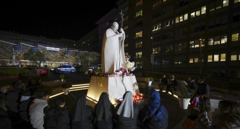 People pray for Pope Francis in front of the Agostino Gemelli Polyclinic, in Rome, Sunday, Feb. 23, 2025, where the Pontiff is hospitalized since Friday, Feb. 14. (AP Photo/Andrew Medichini)