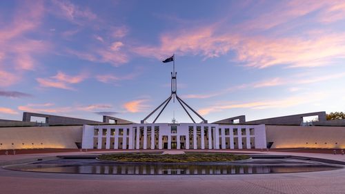 a sunset wide view of federal parliament house at canberra in the act, australia