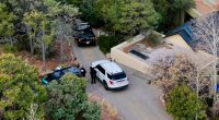 Law enforcement officials talk outside a home