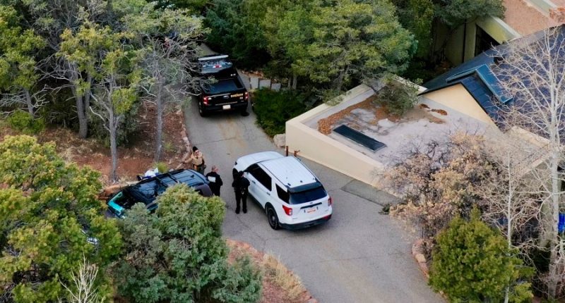 Law enforcement officials talk outside a home