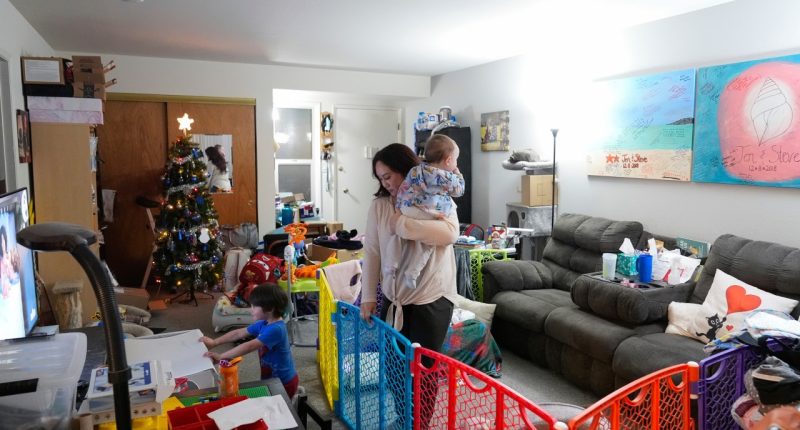 Jennifer Petersen, center, walks with her daughter Carolynn as her son, Jerrick, watches television at their apartment in Campbell, Calif., Wednesday, Jan. 15, 2025. (AP Photo/Godofredo A. Vásquez)
