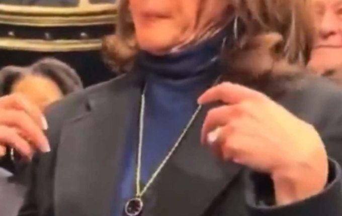 Kamala Harris adjusting her necklace.