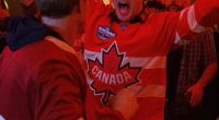 Justin Trudeau wearing a Canada hockey jersey and celebrating.