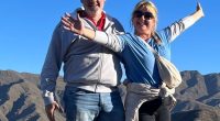 Andrew and Dawn Searle posing for a photo in front of mountains.
