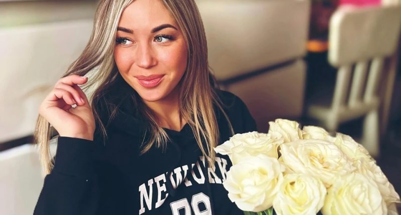Woman holding white roses.