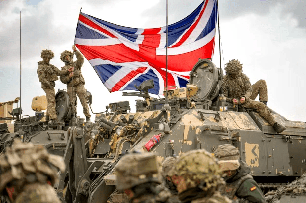 British soldiers with a Union Jack on a military vehicle.