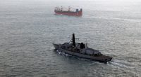 Royal Navy frigate monitoring a Russian merchant ship.