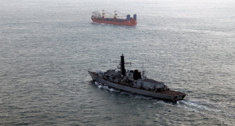 Royal Navy frigate monitoring a Russian merchant ship.