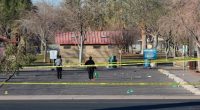 Crime scene technicians at a park parking lot after a mass shooting.