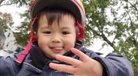 A young boy wearing a helmet and jacket.