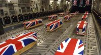 British military caskets draped with Union Jack flags inside a cargo plane.