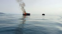 Burning boat in the ocean.
